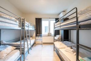 a dorm room with bunk beds and a window at Amazing apartment for 8 with parking space in Ostend +6 photos