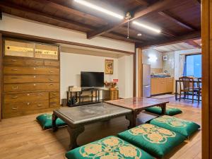 a living room with a table and a kitchen at The Cross Inn Gujo in Gujo