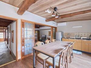 a kitchen and dining room with a wooden table and chairs at The Cross Inn Gujo in Gujo