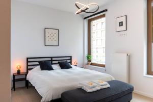 a bedroom with a large white bed with towels on it at Perfectly situated condo with amazing views in Ostend