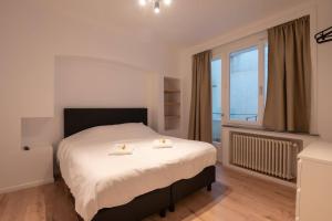 a bedroom with a bed with two candles on it at Appartement Montfleuri in Ostend