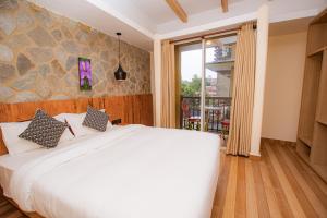 a bedroom with a large white bed and a window at Bodhi Suite Boutique Hotel & Wellness in Pokhara +112 photos
