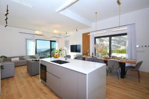 a kitchen and living room with a table and chairs at Moderna villa "Split na dlanu" s grijanim bazenom in Klis