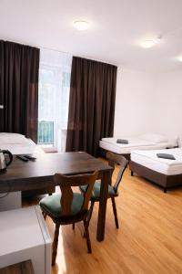 a room with two beds and a table and chairs at Hotel Olimpik Park in Słubice