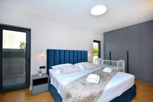 a bedroom with a large bed with a blue headboard at Moderna villa "Split na dlanu" s grijanim bazenom in Klis +44 photos