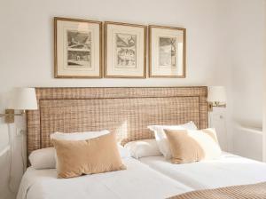 a bed with two pillows and two framed pictures above it at Sevilla Home Center in Seville
