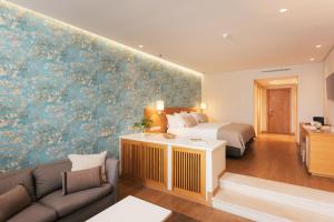 a hotel room with a bed and a couch at Falésia Hotel - Adults Only in Albufeira