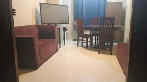 a living room with a couch and a table and chairs at RnR Suites in Dagupan