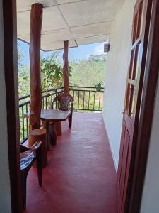 a room with a balcony with a table and chairs at Browns Hill Villa - Ella in Ella