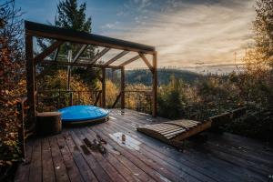 a wooden deck with a bench and a canopy at Domek na drzewie Ceprowo in Szczyrk