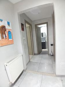 a hallway with a white tile floor and white walls at Super Chiraz Loft in Nabeul +2 photos