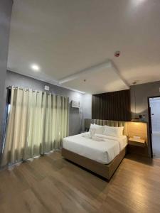 a bedroom with a large white bed and a window at Arpo Hotel San Juan La Union in San Juan