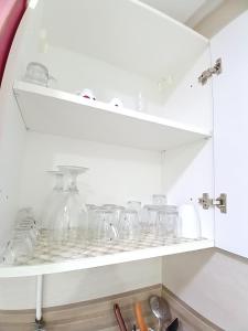 a white shelf with glass jars and other items at Super Chiraz Loft in Nabeul