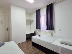 ein Schlafzimmer mit zwei Betten und einem Fenster in der Unterkunft Hostel M in Maribor