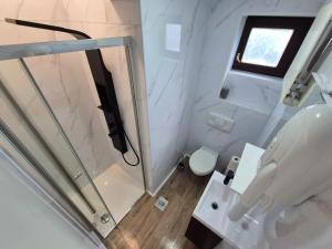 ein weißes Badezimmer mit Toilette und Dusche in der Unterkunft Hostel M in Maribor
