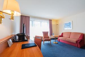 a hotel room with a couch and a table at Parkhotel Bad Homburg in Bad Homburg vor der Höhe