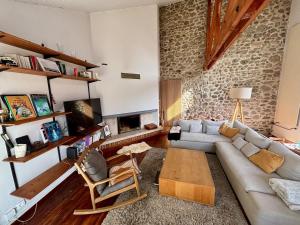 a living room with a couch and a fireplace at Exceptional house with a pool in Jarrie