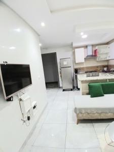 a white living room with a couch and a kitchen at Super Chiraz Loft in Nabeul