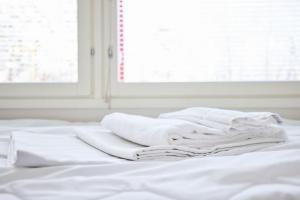 a pile of white towels sitting on top of a bed at Hostel Linnasmäki in Turku