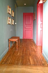 a room with a red door and a wooden floor at Le Jardin Secret in Monflanquin