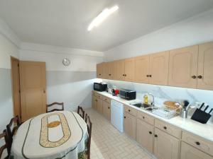 a kitchen with a table and a sink and a counter at Casa Santos Faro Beach in FAO