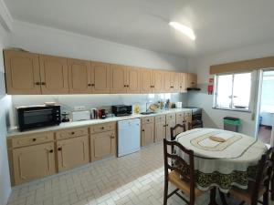 a kitchen with a table and a microwave and a table with chairs at Casa Santos Faro Beach in FAO +30 photos