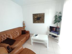a living room with a brown couch and a white table at Casa Santos Faro Beach in FAO
