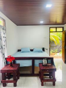 a bedroom with a large bed with two tables at Hobbit in Midigama East