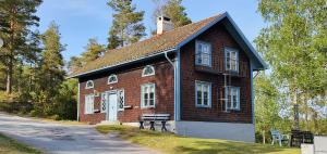 a small red brick building with a white door at Vandrarhemmet Gammelgården in Bengtsfors