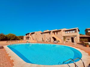 a large swimming pool in front of a building at Baja Sardinia Casetta Belvedere 2 with Pool 100m from the Beach in Baja Sardinia