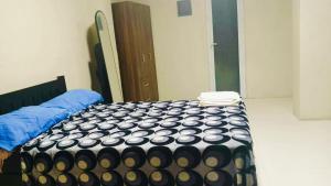 a bedroom with a bed with a black and white comforter at RnR Suites in Dagupan +2 photos