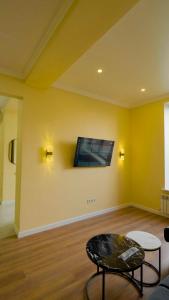 a living room with a tv on a yellow wall at Esal Manas in Jalal-Abad