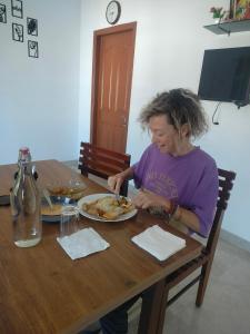 a woman sitting at a table with a plate of food at Asprin Homestay in Munnar