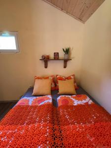 a bedroom with a bed with a red comforter at Unique Dutch Retro House "Stará Láska" - Natural Slovakia in Modrý Kameň