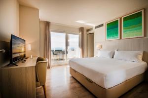 a hotel room with a large bed and a television at Hotel Marina in Roses