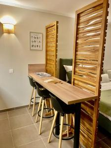 a dining room with a wooden table and stools at Appartement en résidence d'exception avec piscine dans le cap corse in Sisco