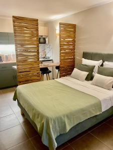 a bedroom with a large bed and a kitchen at Appartement en résidence d'exception avec piscine dans le cap corse in Sisco