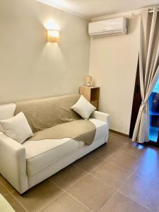 a living room with a white couch and a window at Appartement en résidence d'exception avec piscine dans le cap corse in Sisco +10 photos