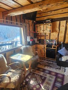 a living room with a table and chairs in a cabin at Casa rustica in Braşov