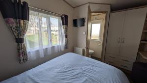 a bedroom with a bed and a window at M6 Mallard Rise in Goodrington +28 photos