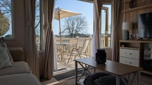 a living room with a table and a patio with an umbrella at M6 Mallard Rise in Goodrington