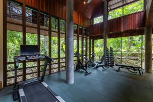 a gym with treadmills and exercise bikes in a building at Khaolak Wanaburee Resort - SHA Extra Plus in Khao Lak