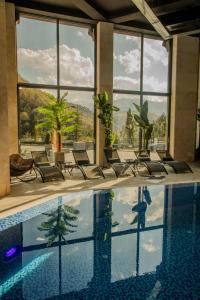 ein Pool in einem Hotel mit Stühlen und Fenstern in der Unterkunft Mounthree in Pʼambak