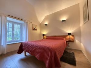 a bedroom with a red bed and a window at Millerou in Montory