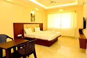 a bedroom with a bed and a desk and a table at Siddarth Residency in Channarāyapatna