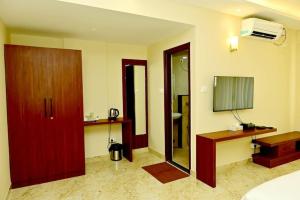 a room with a bed and a desk and a mirror at Siddarth Residency in Channarāyapatna