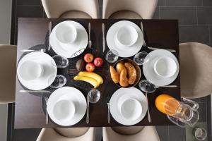 a person with a plate of food and wine glasses at Horizon 62 I Zürich Lakeside Apartment I Modern I Free Parking I Self-Check-In in Richterswil