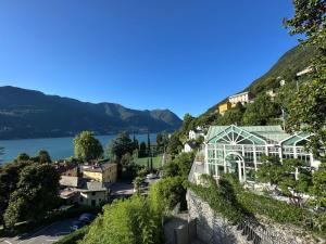 a building on a hill next to a body of water at LA CALETTA SUITE APARTMENT- Panoramic Shared Pool, Secured Parking, Water Activities in Blevio +24 photos