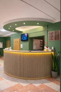an office lobby with a reception counter and a flat screen tv at Hotel Olimpik Park in Słubice