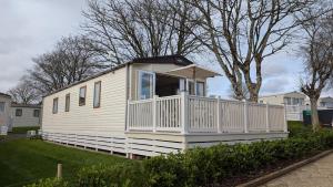 a white tiny house with a porch on a yard at M6 Mallard Rise in Goodrington